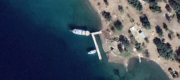Яхты и причал в бухте Чайки на снимке из космоса. Скопиа Лимани. Турция