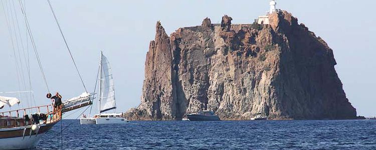 Яхты у скалы рядом с островом Стромболи. Липарский архипелаг. Сицилия. Италия