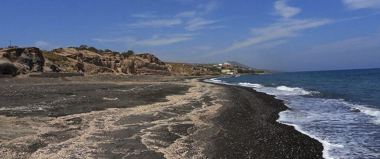 Пляж с черной вулканияеской галькой на на Санторине