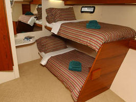 Guest Cabin with 2 Upper/Lower single beds. A third single bed can be added for charters with 9 guests.